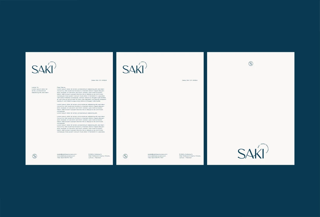 SAKI cream letterhead and stationery system against deep teal.