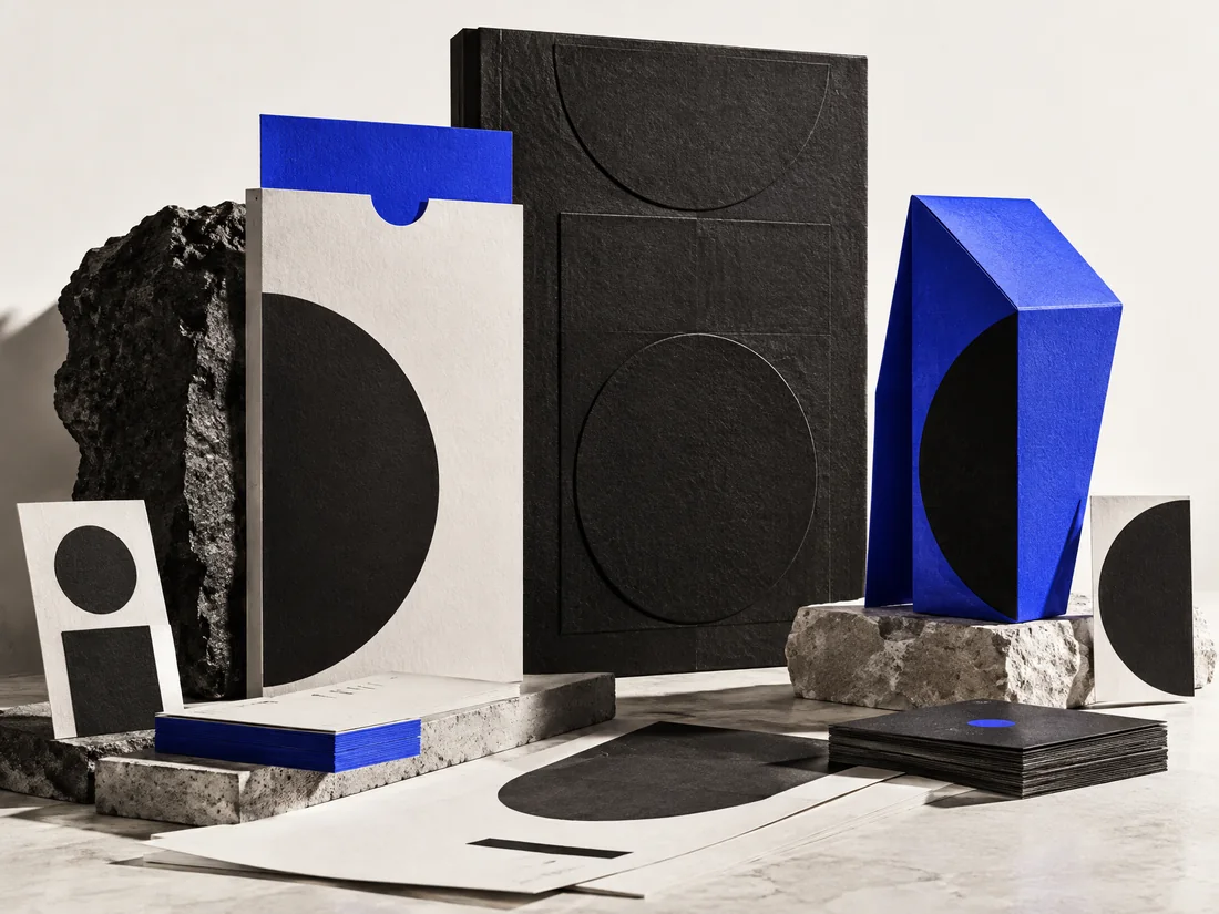 Fictional editorial still life of paper, packaging and cobalt forms illustrating brand design.